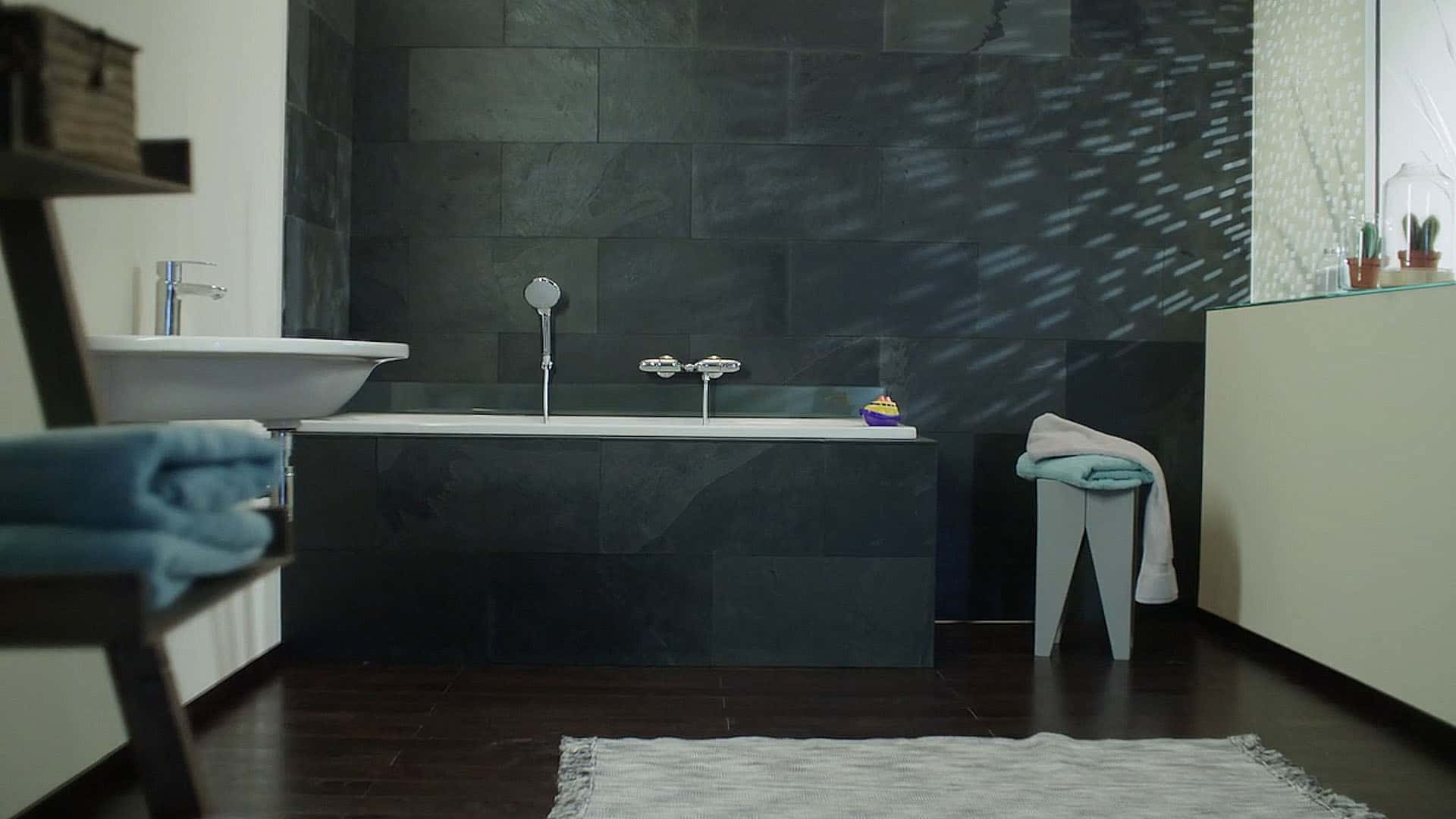 Ein schwarzes modernes Badezimmer mit Badewanne und weiteren Sanitäreinrichtungen von Sanitary by Grohe AG.