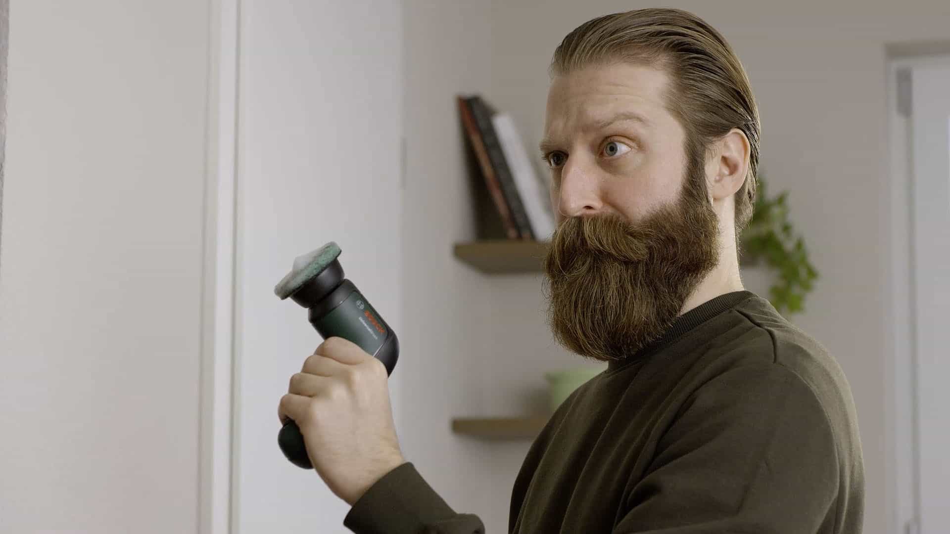 Seriös schauender Darsteller hält den Universal Brush von Bosch mit schaumigen Aufsatz in der linken Hand.