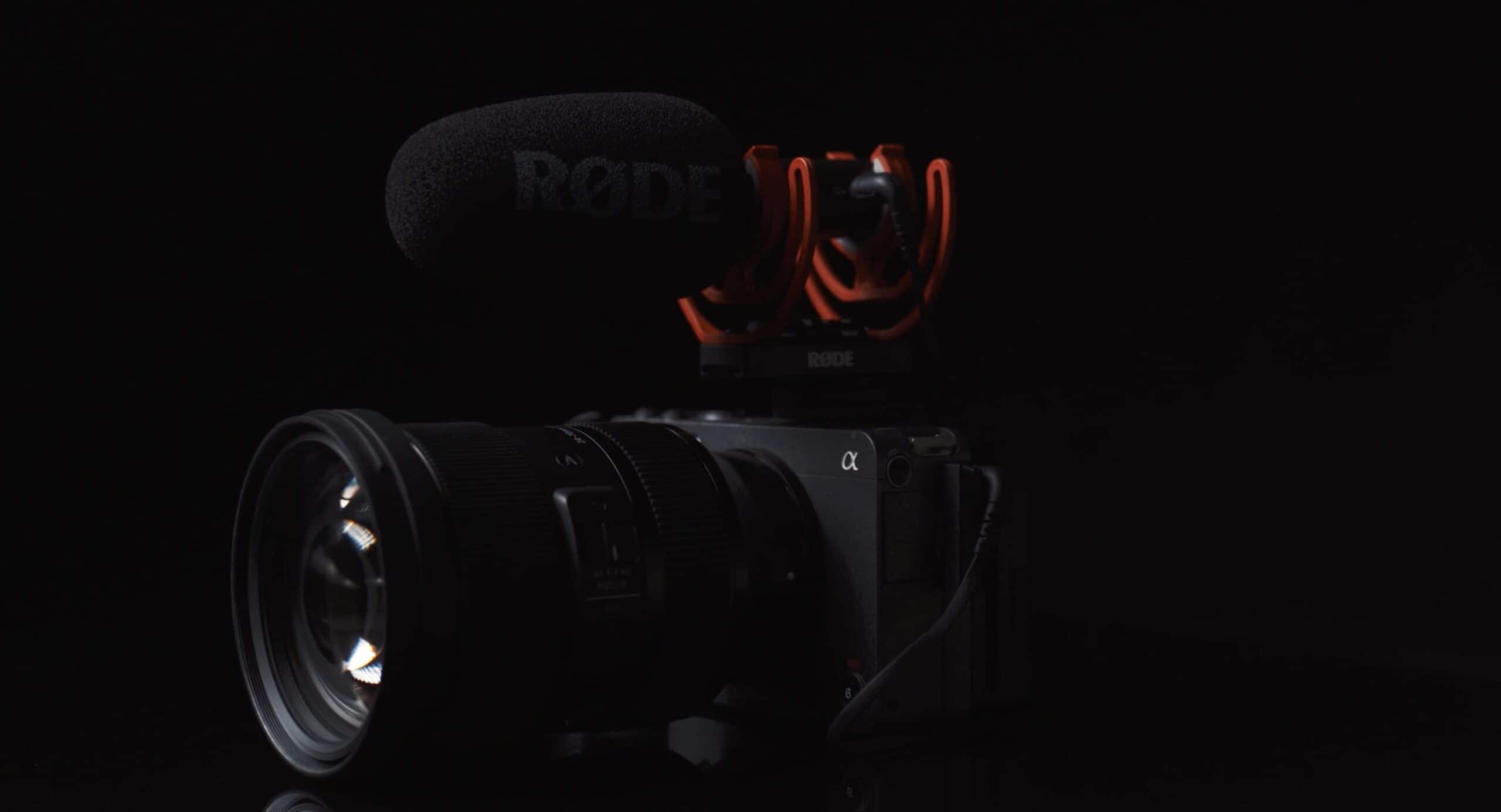 Schwarzes Kamera Mikrofon von Rode mit roter Halterung.